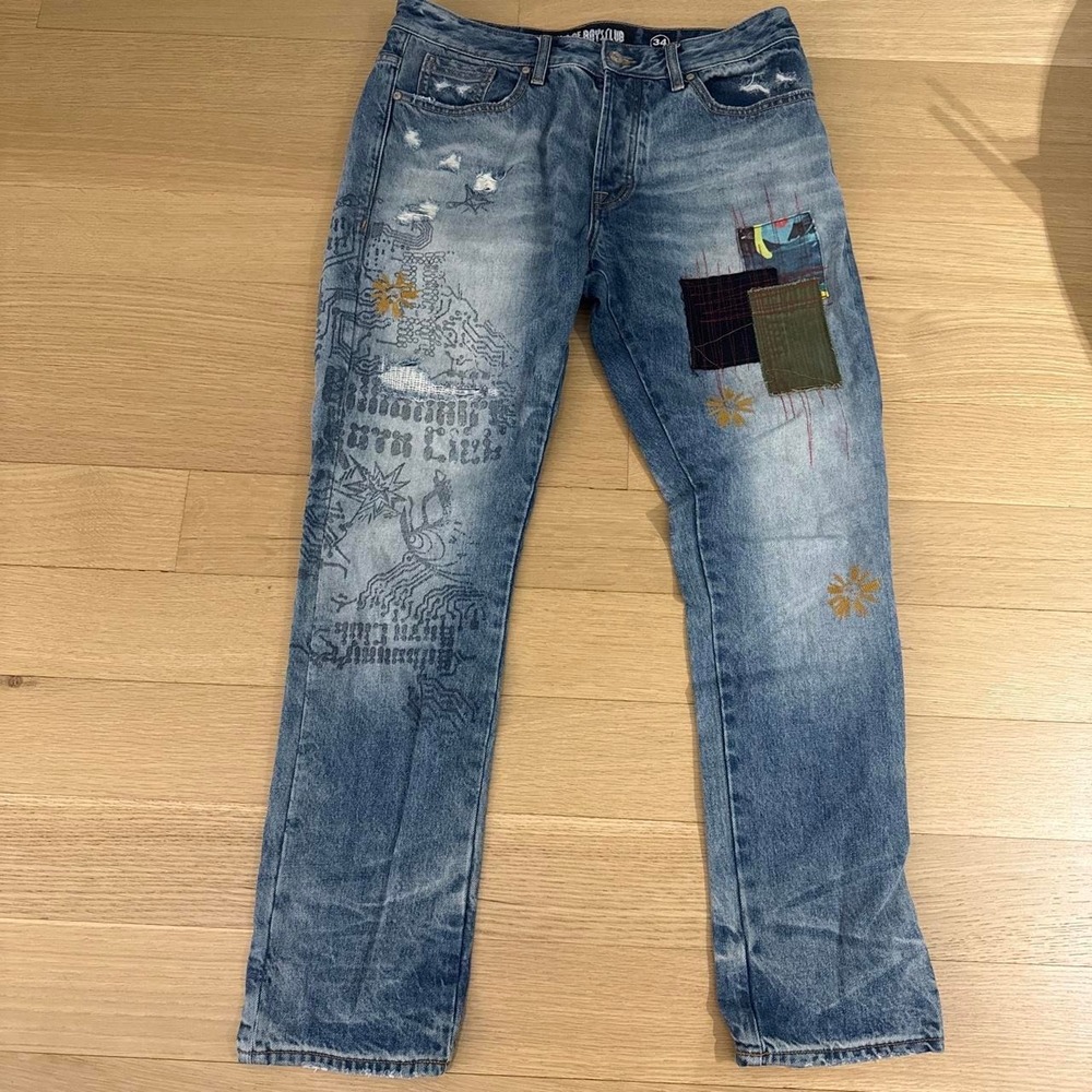 Billionaire Boys Club blue denim jeans with embroidered designs and patches